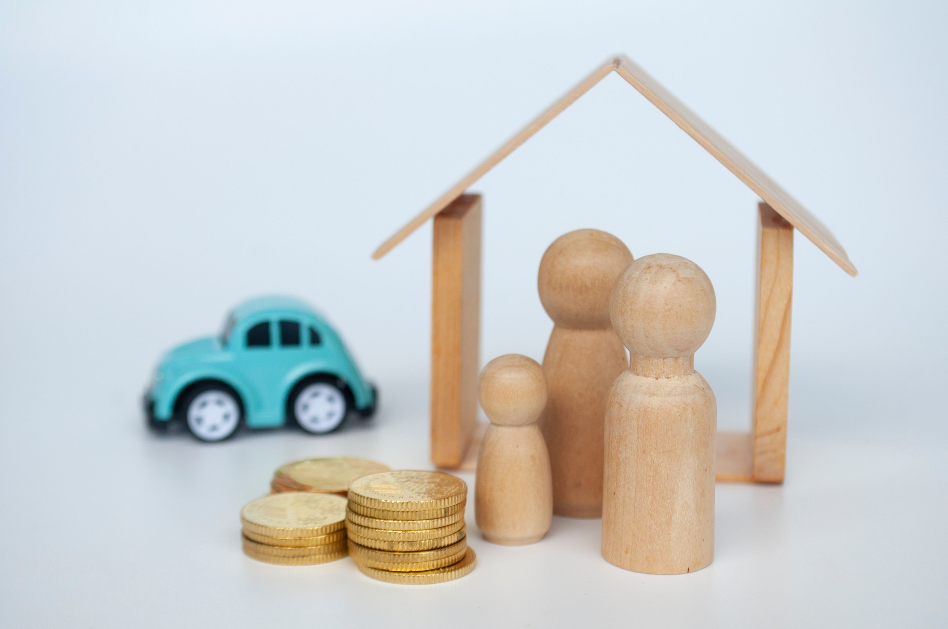 Concepto de seguro con figura familiar, monedas de oro y fondo de coche borroso.