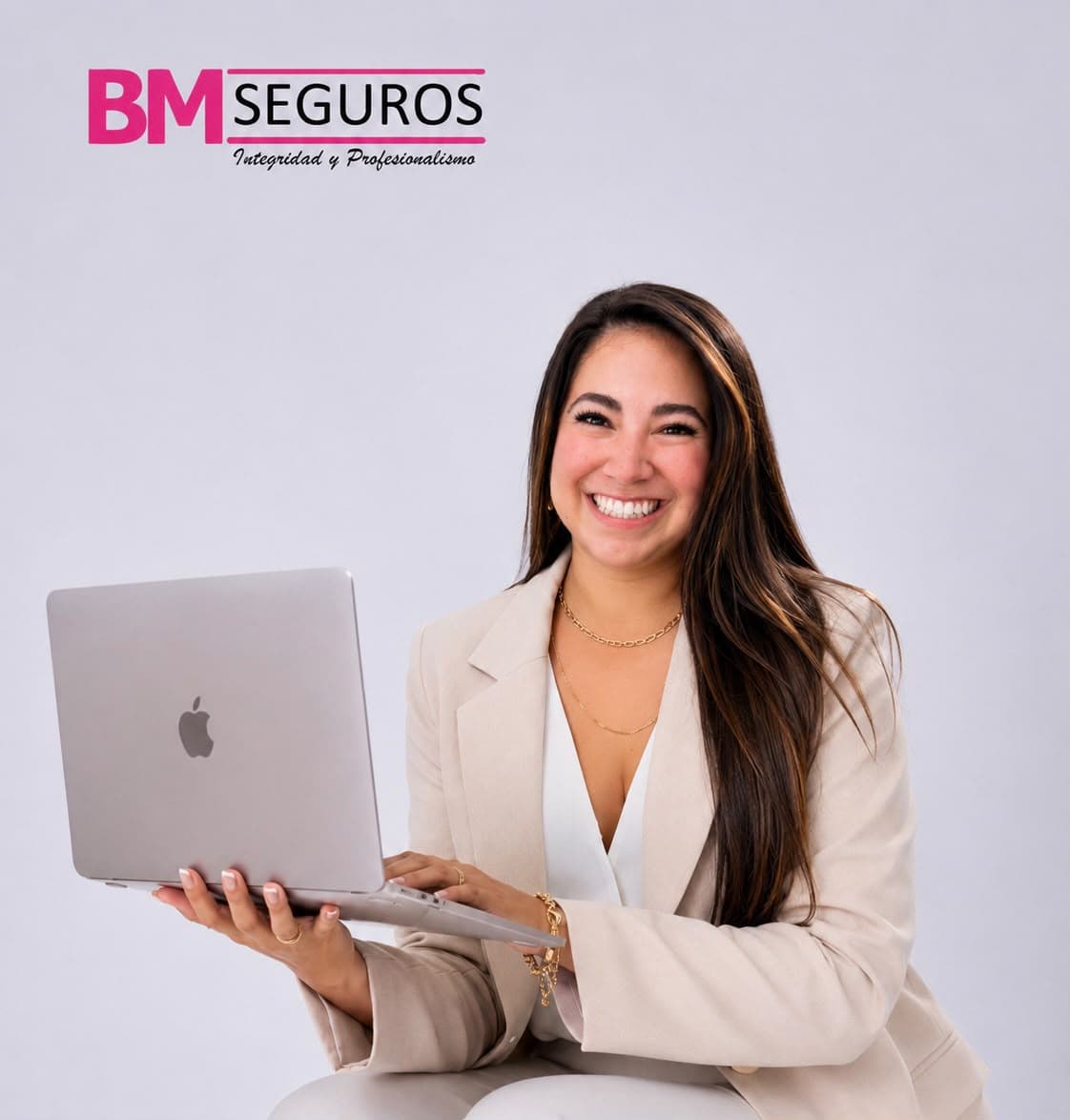 Mujer profesional sonriente con blazer beige sosteniendo una computadora portátil y logo de BM Seguros.